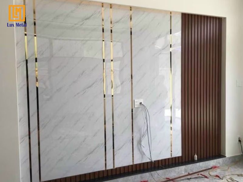 Hoàn thiện thi công dán nẹp la inox vàng gương lên tường